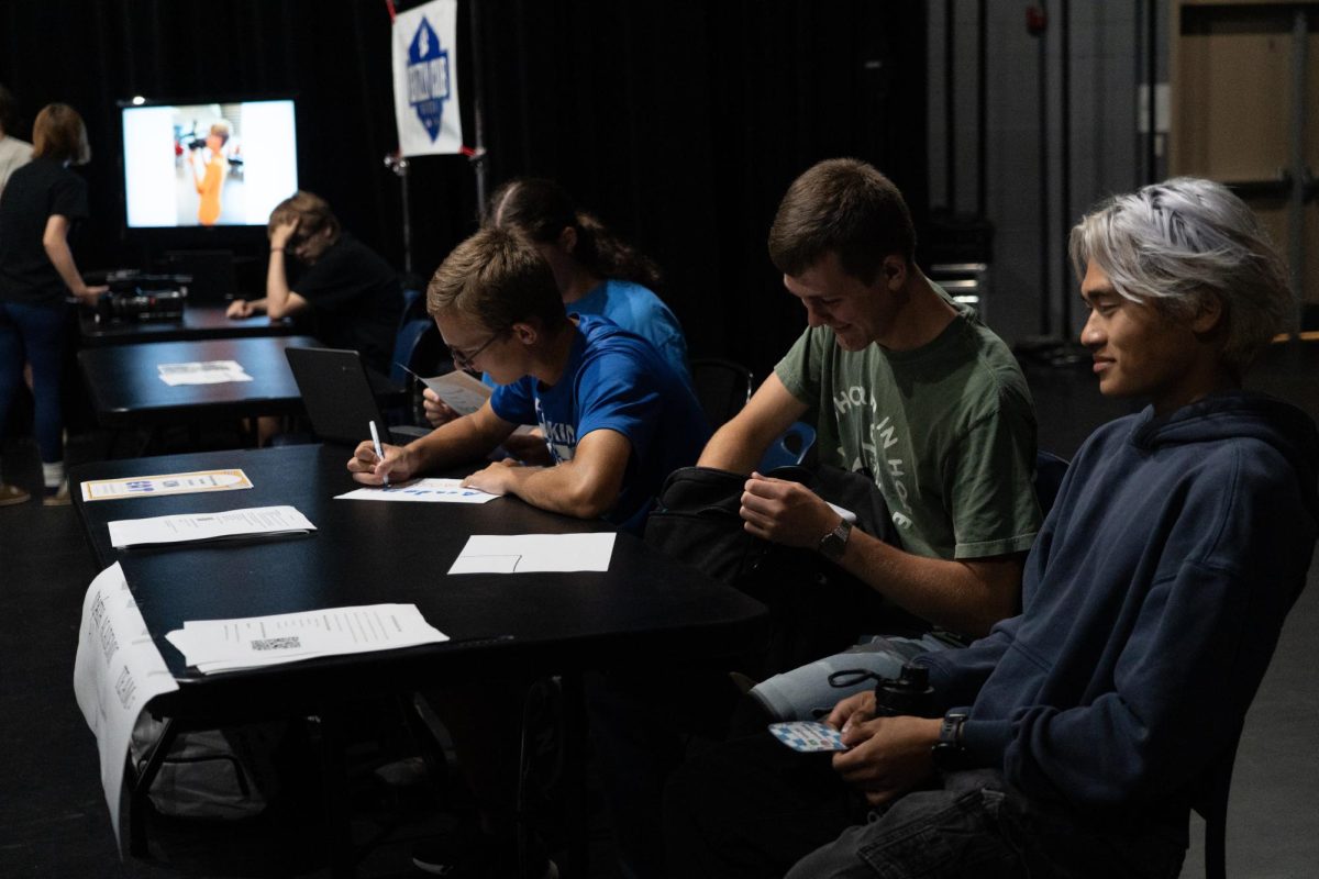 Members of academic teams prepare their table.