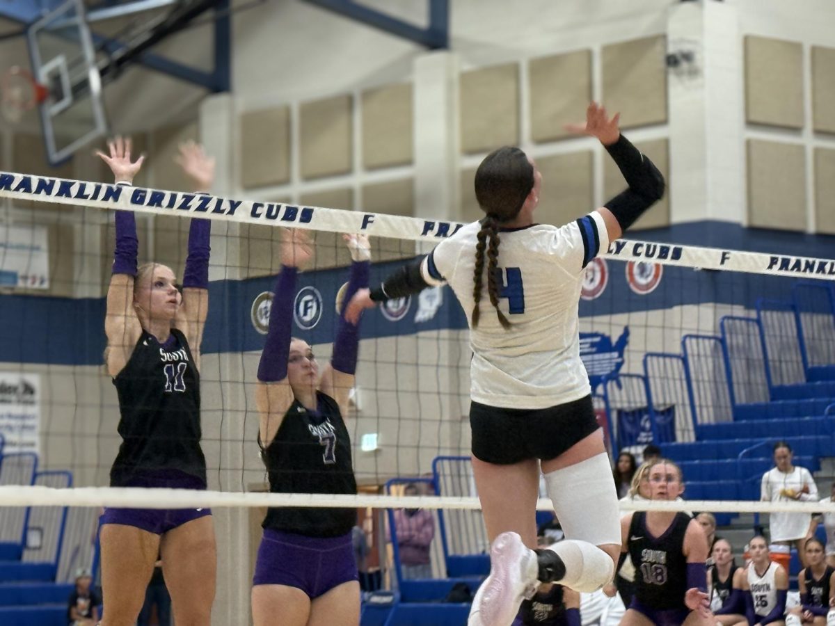 Rose Mahin spiking over two defenders