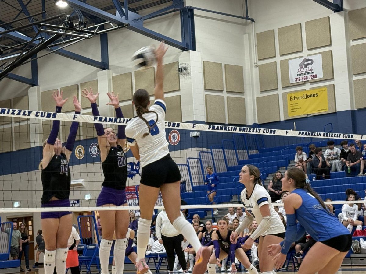 Addie Martin spiking on two defenders
