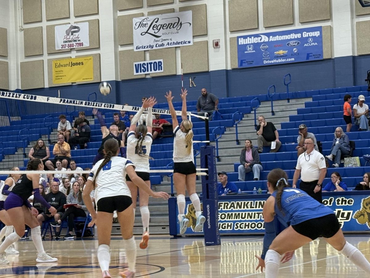 Ava Lilly and Karlin Burton blocking a spike